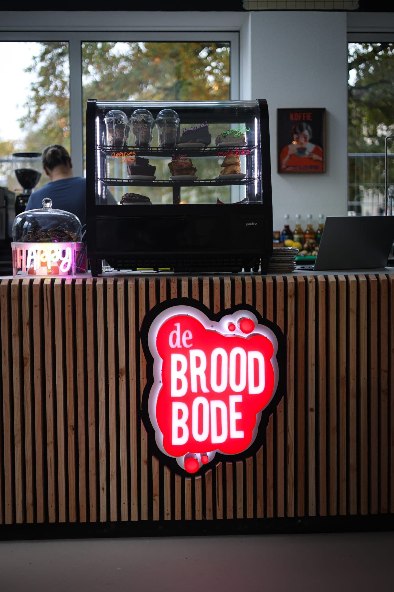 Verlichte counter met houten lamellen en het logo van De Broodbode in Zwolle, afgebouwd door Afbouwstudio (MTB Bouw)